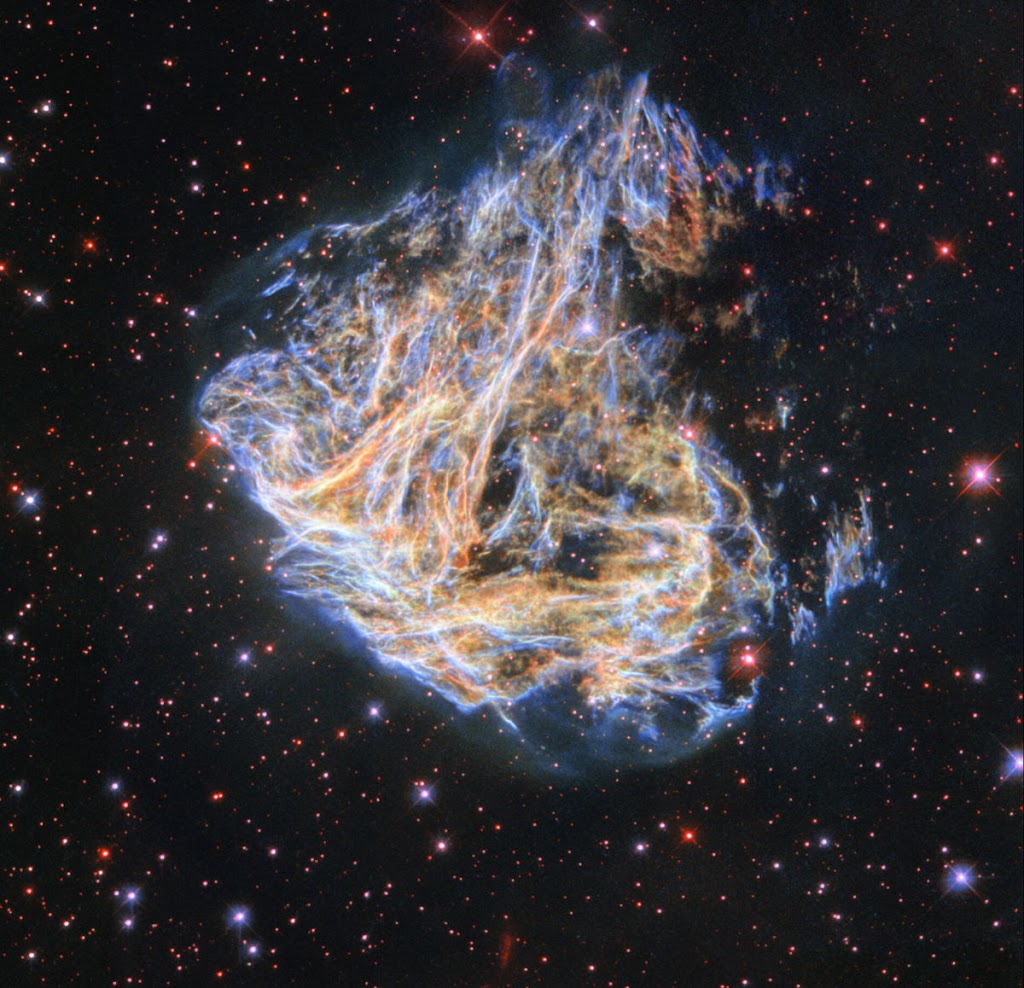 The Hubble Telescope shows a fragment of a brightly colored supernova remnant.